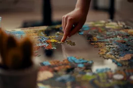 Finger pointing at jigsaw puzzle